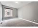 A light and airy empty bedroom with a large window and plush carpeting at 5506 Malta St, Denver, CO 80249
