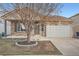 Charming stone home with a well-maintained front yard and attached two car garage at 5506 Malta St, Denver, CO 80249