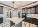 This kitchen boasts an island with marble countertops, stainless steel appliances, and dark cabinetry at 5506 Malta St, Denver, CO 80249