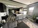 Wide open kitchen features a center island, stainless appliances, a breakfast bar, and an adjacent living space at 5506 Malta St, Denver, CO 80249