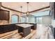 Modern kitchen featuring dark cabinets, an island with seating, stylish countertops, and hardwood floors at 5506 Malta St, Denver, CO 80249
