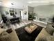 Open-concept living and dining area with modern gray floors, comfortable seating, and stylish decor at 5506 Malta St, Denver, CO 80249