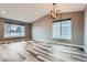 Bright living room with large windows, vaulted ceilings, recessed lighting, and modern gray flooring at 5506 Malta St, Denver, CO 80249