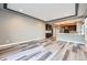Spacious living room view showcasing the open layout with a partial kitchen view, recessed lights, and neutral paint at 5506 Malta St, Denver, CO 80249