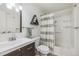 Bright bathroom features white tiles, a dark vanity, and a shower with curtain at 17493 E Mansfield Ave # 1231L, Aurora, CO 80013