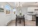 Bright dining area features modern chandelier, large windows, and neutral paint at 17493 E Mansfield Ave # 1231L, Aurora, CO 80013