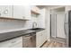 Bright kitchen featuring white cabinets, dark countertops, stainless steel appliances, and hardwood floors at 17493 E Mansfield Ave # 1231L, Aurora, CO 80013