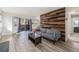 Bright living room with wood accent wall, light floors, and sliding glass door to a patio at 17493 E Mansfield Ave # 1231L, Aurora, CO 80013