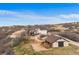 An aerial view of a property showing a house, horse barn and fenced area at 3074 Castle Butte Dr, Castle Rock, CO 80109