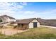 A tan barn with brown trim and dark barn doors with a pasture beside the barn at 3074 Castle Butte Dr, Castle Rock, CO 80109