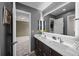 Bathroom with double vanity, modern lighting, and access to another room at 3074 Castle Butte Dr, Castle Rock, CO 80109