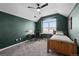 Bedroom with a large window, desk, and single bed with green accent wall at 3074 Castle Butte Dr, Castle Rock, CO 80109