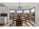 Charming dining area with a wooden table, seating for four, and picturesque views from the surrounding windows at 3074 Castle Butte Dr, Castle Rock, CO 80109