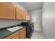 Functional laundry room with modern washer and dryer, plenty of storage, and a utility sink at 3074 Castle Butte Dr, Castle Rock, CO 80109