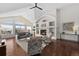 Spacious living room featuring a stone fireplace, large windows with views, and hardwood floors at 3074 Castle Butte Dr, Castle Rock, CO 80109