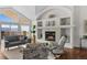 Bright living room features large windows and a stone fireplace providing a warm ambiance with comfortable seating at 3074 Castle Butte Dr, Castle Rock, CO 80109
