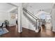 Elegant staircase with hardwood floors, a white and black banister, and abundant natural light at 3074 Castle Butte Dr, Castle Rock, CO 80109