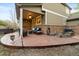 Covered patio with brick and siding accents, dining area, and hot tub at 6987 Esperanza Dr, Castle Pines, CO 80108