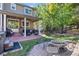 Backyard with covered patio featuring brick accents, dining area, hot tub, and gas grill at 6987 Esperanza Dr, Castle Pines, CO 80108