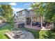 An inviting backyard features a patio with outdoor seating, a built-in grill, a fire pit and a relaxing hot tub at 6987 Esperanza Dr, Castle Pines, CO 80108