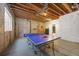 Unfinished basement featuring ping pong table, cement floor, exposed ceiling, and shelving at 6987 Esperanza Dr, Castle Pines, CO 80108