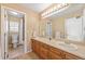 Bright bathroom with double vanity, large mirror, and a shower-tub combo with tile flooring at 6987 Esperanza Dr, Castle Pines, CO 80108