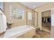 A bright bathroom with soaking tub, glass enclosed shower and walk-in closet at 6987 Esperanza Dr, Castle Pines, CO 80108