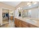 This primary bath features dual sinks with wood cabinets and a large mirror at 6987 Esperanza Dr, Castle Pines, CO 80108
