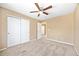 Tan bedroom featuring carpet, a ceiling fan, and a closet with white panel doors at 6987 Esperanza Dr, Castle Pines, CO 80108