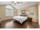 A serene bedroom featuring hardwood floors, a king-size bed, and ample natural light offers a relaxing retreat at 6987 Esperanza Dr, Castle Pines, CO 80108