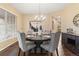 Comfortable dining area with a dark table, chandelier, and seating for four at 6987 Esperanza Dr, Castle Pines, CO 80108