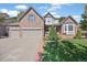 Charming brick home with a three-car garage, manicured lawn, and lovely curb appeal at 6987 Esperanza Dr, Castle Pines, CO 80108