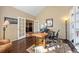 Bright home office with French doors, hardwood floors, and built-in bookshelves offers a dedicated workspace at 6987 Esperanza Dr, Castle Pines, CO 80108