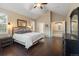 Vaulted ceiling main bedroom featuring wood floors, large bed, and a doorway leading to the main bathroom at 6987 Esperanza Dr, Castle Pines, CO 80108