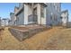 Exterior angle of a home featuring blue siding, a retaining wall, and a yard under construction at 7199 Waterleaf Trl, Littleton, CO 80125