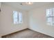 Well-lit bedroom featuring neutral carpet, two windows, and white walls at 7199 Waterleaf Trl, Littleton, CO 80125