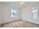 Bright bedroom with neutral carpet, a light fixture, and ample natural light from two windows at 7199 Waterleaf Trl, Littleton, CO 80125