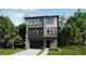 Modern two-story home showcasing a minimalist design, large windows, and a welcoming front entrance, all surrounded by lush greenery at 7199 Waterleaf Trl, Littleton, CO 80125