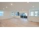 Bright, open-concept living room with hardwood floors and access to outdoor balcony at 7199 Waterleaf Trl, Littleton, CO 80125