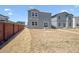 Spacious backyard with a modern home and a wood fence, perfect for outdoor activities at 2222 Flower Blossom Ave, Brighton, CO 80601