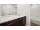 Bathroom featuring a single sink vanity with sleek cabinets, a large mirror and a shower at 2222 Flower Blossom Ave, Brighton, CO 80601