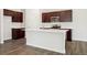 Modern kitchen with dark wood cabinets, stainless steel appliances, and a white center island at 2222 Flower Blossom Ave, Brighton, CO 80601