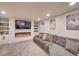 Finished basement with a gray sectional sofa, an electric fireplace, and built in shelving at 15818 W 95Th Ave, Arvada, CO 80007