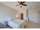 Bedroom with a queen-sized bed, ceiling fan, and walk-in closet with a bright orange interior at 15818 W 95Th Ave, Arvada, CO 80007