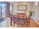 Cozy dining room featuring a wooden table with seating for six, a modern light fixture and access to back deck at 15818 W 95Th Ave, Arvada, CO 80007