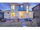 Modern home featuring a stone facade, large windows, landscaped front yard, and welcoming front entrance at 15818 W 95Th Ave, Arvada, CO 80007