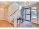 Bright foyer featuring hardwood floors, a staircase, and a view of the exterior through the front door at 15818 W 95Th Ave, Arvada, CO 80007