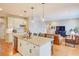 Open kitchen featuring a granite island with seating, modern lighting, and stainless steel appliances next to the living room at 15818 W 95Th Ave, Arvada, CO 80007