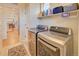 Laundry room with modern washer and dryer, storage shelves, and tile flooring at 15818 W 95Th Ave, Arvada, CO 80007