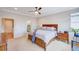 Spacious main bedroom featuring a ceiling fan, bedside table, and ensuite bathroom at 15818 W 95Th Ave, Arvada, CO 80007